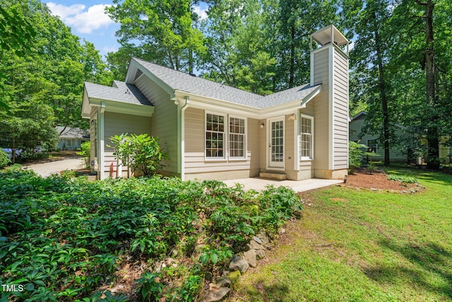117 Summerlin Dr, Chapel Hill, NC 27514 - view of property exterior featuring a shingled roof, a chimney, a yard, and a patio area