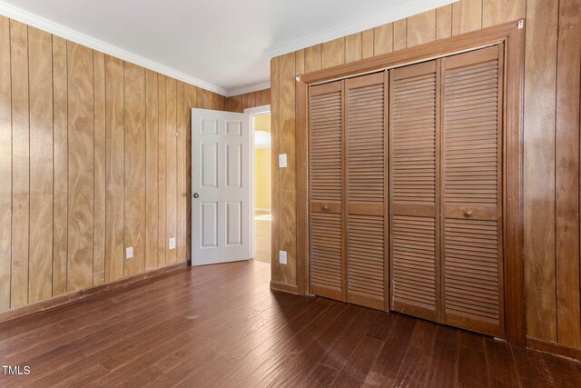 403 S Webb St, Selma, NC 27576 - unfurnished bedroom with a closet, hardwood / wood-style flooring, wooden walls, and ornamental molding