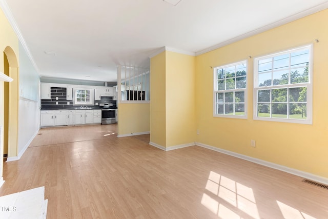 403 S Webb St, Selma, NC 27576 - unfurnished living room with ornamental molding, light wood finished floors, baseboards, and a sink