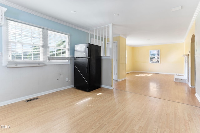 403 S Webb St, Selma, NC 27576 - kitchen featuring freestanding refrigerator, light wood-style floors, crown molding, baseboards, and arched walkways