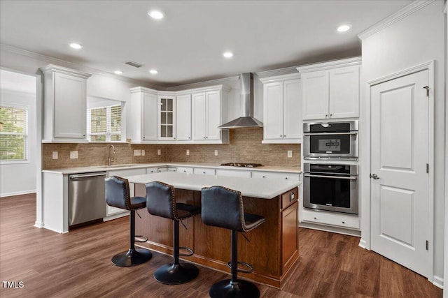 1704 Fawn Chase Ct, Wake Forest, NC 27587 - kitchen featuring wall chimney range hood, appliances with stainless steel finishes, light countertops, a center island, and white cabinets