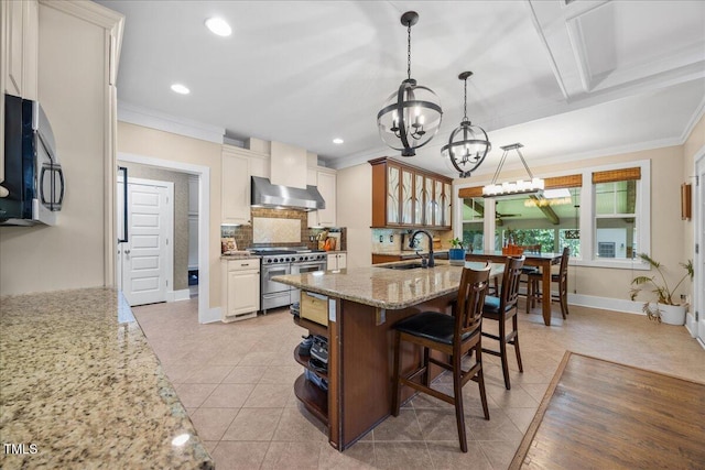 12636 Old Creedmoor Rd, Raleigh, NC 27613 - kitchen with range with two ovens, wall chimney range hood, a chandelier, ornamental molding, and backsplash