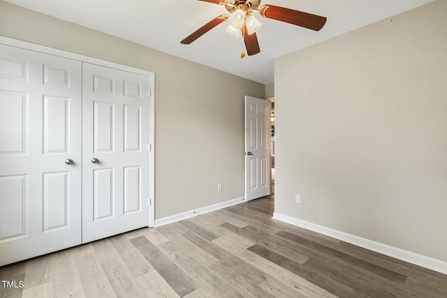 366 E Smithfield St, Angier, NC 27501 - unfurnished bedroom featuring wood finished floors, baseboards, a ceiling fan, and a closet