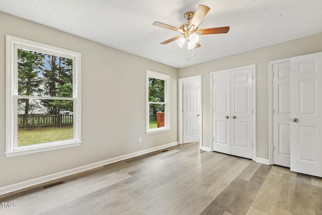 366 E Smithfield St, Angier, NC 27501 - unfurnished bedroom with light wood-type flooring, baseboards, a ceiling fan, and a textured ceiling