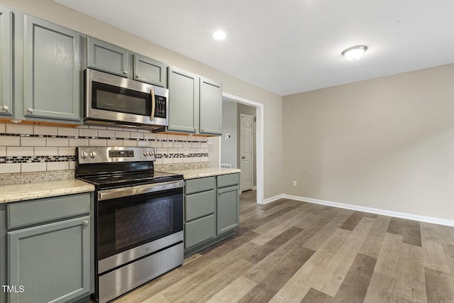 366 E Smithfield St, Angier, NC 27501 - kitchen featuring stainless steel appliances, backsplash, baseboards, light wood-type flooring, and recessed lighting