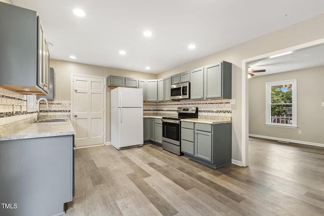 366 E Smithfield St, Angier, NC 27501 - kitchen with appliances with stainless steel finishes, a sink, gray cabinets, backsplash, and recessed lighting