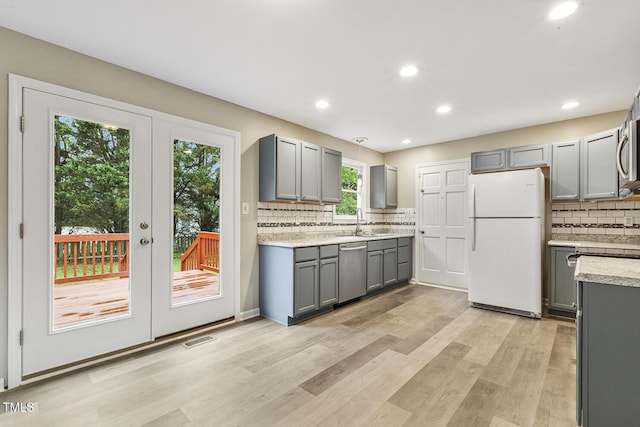 366 E Smithfield St, Angier, NC 27501 - kitchen featuring stainless steel appliances, gray cabinets, tasteful backsplash, light countertops, and a sink