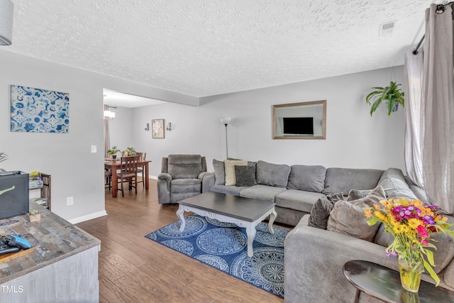 8361 Mcguire Dr, Raleigh, NC 27616 - living area with wood finished floors, a textured ceiling, and a chandelier