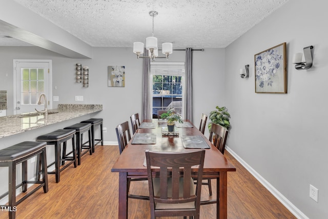 8361 Mcguire Dr, Raleigh, NC 27616 - dining room featuring wood finished floors, a chandelier, and a textured ceiling