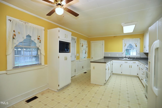 2006 N Ashland Dr, Burlington, NC 27217 - kitchen with black microwave, light floors, dark countertops, crown molding, and a peninsula