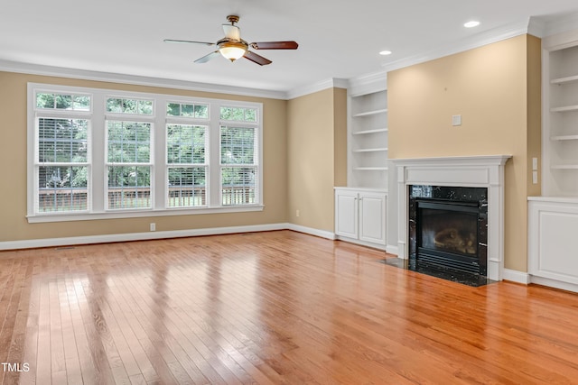 225 Norwalk St, Holly Springs, NC 27540 - unfurnished living room featuring built in shelves, plenty of natural light, hardwood / wood-style floors, and ornamental molding