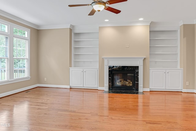 225 Norwalk St, Holly Springs, NC 27540 - unfurnished living room with built in shelves, healthy amount of natural light, wood finished floors, crown molding, and ceiling fan