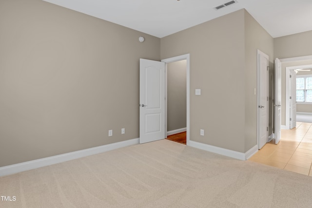225 Norwalk St, Holly Springs, NC 27540 - unfurnished bedroom featuring light colored carpet, baseboards, and light tile patterned floors