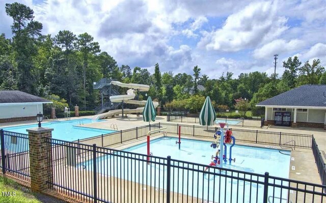 225 Norwalk St, Holly Springs, NC 27540 - community pool with a water slide, a patio, and view of wooded area