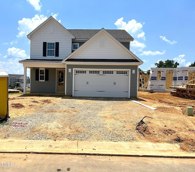 21 Windflower Ct Unit 11, Clayton, NC 27520 - view of front of house with gravel driveway, a garage, covered porch, and roof with shingles