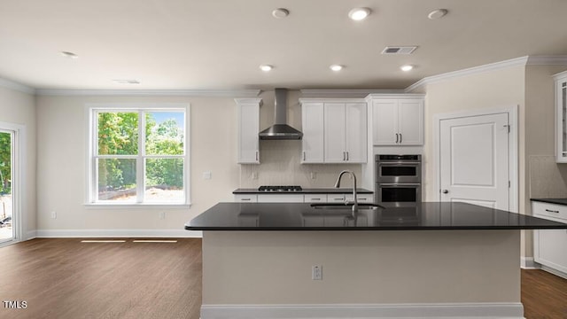 194 Gilmer St, Fuquay Varina, NC 27526 - kitchen featuring wall chimney range hood, a sink, stainless steel double oven, dark countertops, and dark wood-type flooring
