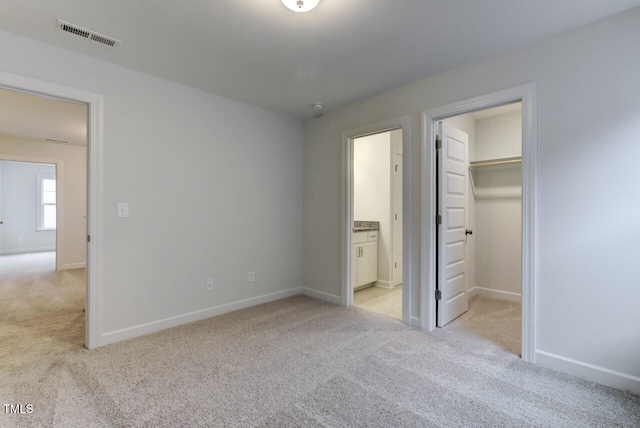 2309 Redbridge Ln, Apex, NC 27502 - unfurnished bedroom with light colored carpet, a walk in closet, baseboards, and ensuite bathroom