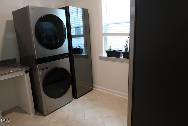 2309 Redbridge Ln, Apex, NC 27502 - laundry area featuring stacked washer and clothes dryer, light tile patterned floors, and baseboards