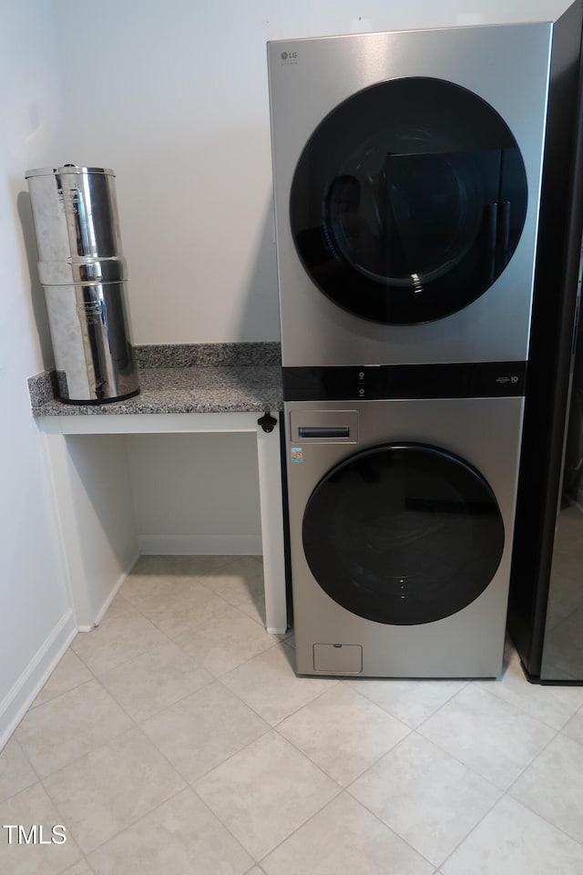 2309 Redbridge Ln, Apex, NC 27502 - laundry area featuring stacked washing machine and dryer, light tile patterned floors, and baseboards