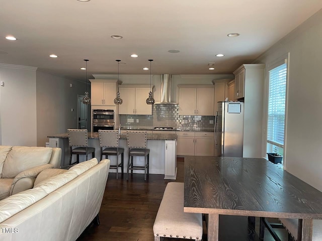 2309 Redbridge Ln, Apex, NC 27502 - kitchen with stainless steel appliances, wall chimney exhaust hood, crown molding, a kitchen breakfast bar, and backsplash