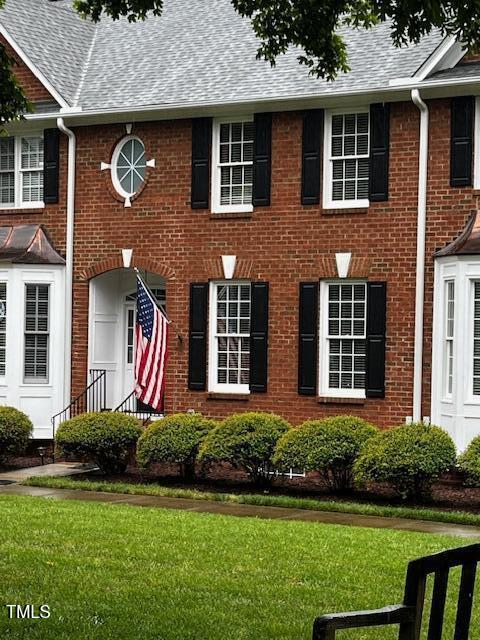 227 Kenmont Dr, Holly Springs, NC 27540 - view of front facade with roof with shingles, brick siding, and a front lawn