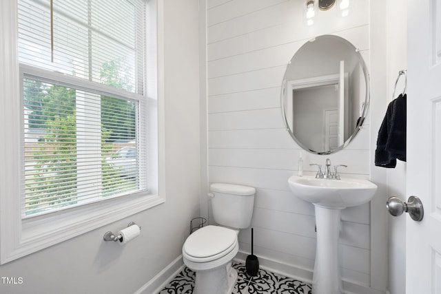 389 Whetstone Dr, Angier, NC 27501 - half bathroom with plenty of natural light, toilet, baseboards, and wooden walls