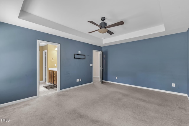 211 Westgrove Ct, Durham, NC 27703 - unfurnished bedroom featuring a tray ceiling, baseboards, carpet flooring, and connected bathroom