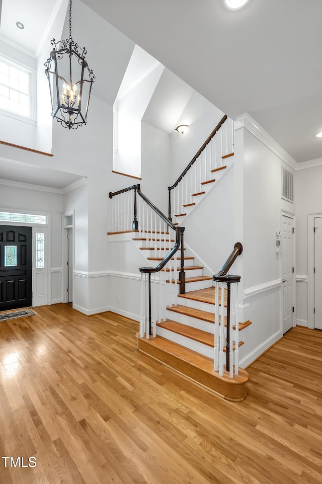100 Sundance Pl, Chapel Hill, NC 27514 - foyer entrance with wood finished floors, a chandelier, stairway, ornamental molding, and a towering ceiling