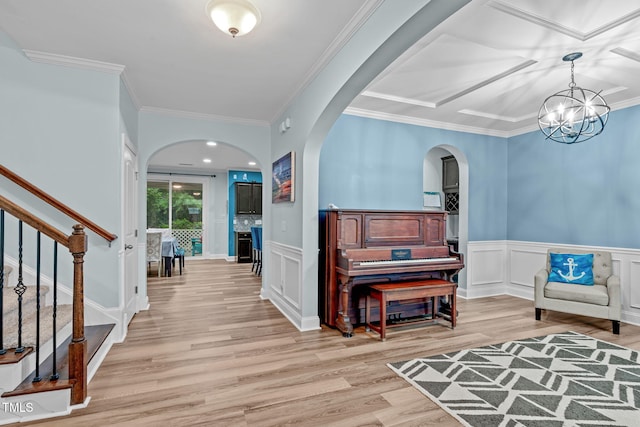 1939 Mostyn Ln, Apex, NC 27502 - foyer featuring arched walkways, light wood-style floors, a chandelier, stairway, and a wainscoted wall