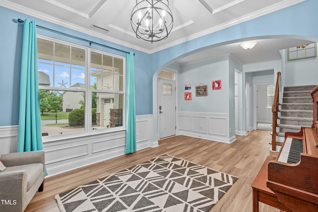 1939 Mostyn Ln, Apex, NC 27502 - entryway featuring arched walkways, a chandelier, light wood-style floors, stairs, and crown molding