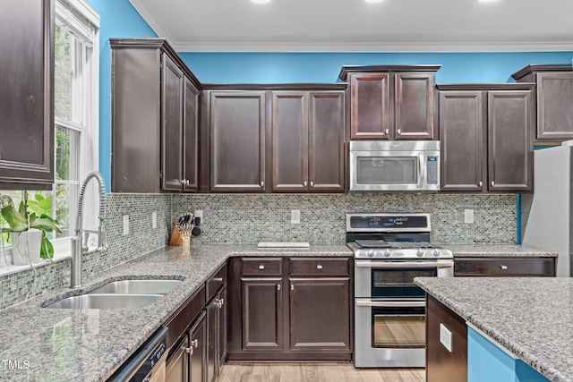 1939 Mostyn Ln, Apex, NC 27502 - kitchen with stainless steel appliances, a sink, crown molding, dark brown cabinets, and light wood finished floors