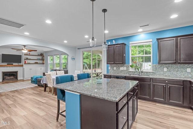 1939 Mostyn Ln, Apex, NC 27502 - kitchen featuring a sink, a breakfast bar area, open floor plan, a ceiling fan, and dark brown cabinets