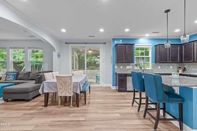 1939 Mostyn Ln, Apex, NC 27502 - dining space with crown molding, recessed lighting, light wood-style flooring, arched walkways, and baseboards