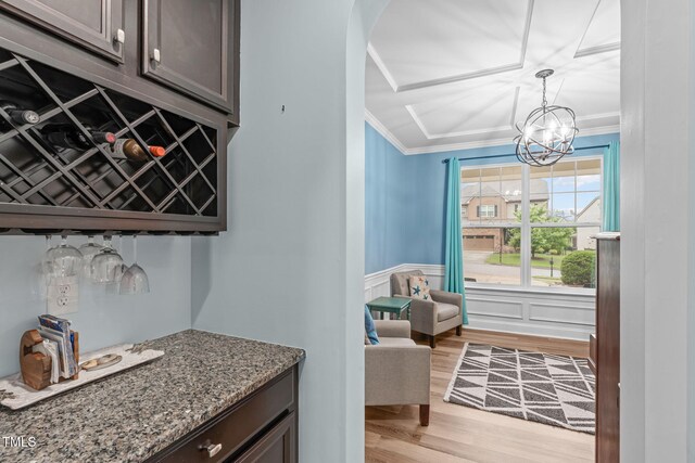 1939 Mostyn Ln, Apex, NC 27502 - bar area with light wood-style floors, ornamental molding, a chandelier, arched walkways, and a wainscoted wall