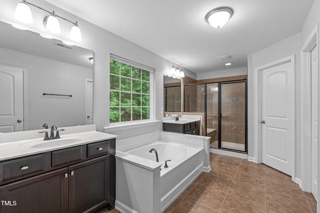 1939 Mostyn Ln, Apex, NC 27502 - full bathroom featuring a shower stall, two vanities, a bath, and tile patterned flooring
