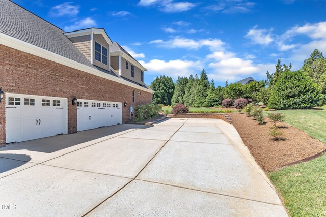 105 Somerley Dr, Garner, NC 27529 - view of side of property with brick siding, concrete driveway, a garage, and roof with shingles