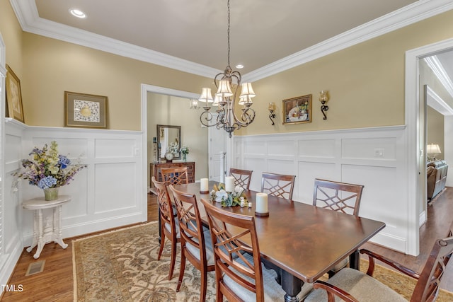 105 Somerley Dr, Garner, NC 27529 - dining room featuring a decorative wall, ornamental molding, wood finished floors, a chandelier, and wainscoting
