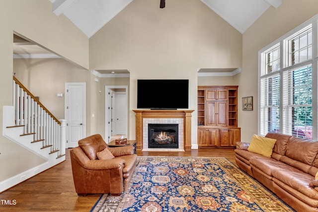 105 Somerley Dr, Garner, NC 27529 - living room featuring high vaulted ceiling, wood finished floors, a fireplace, stairs, and baseboards
