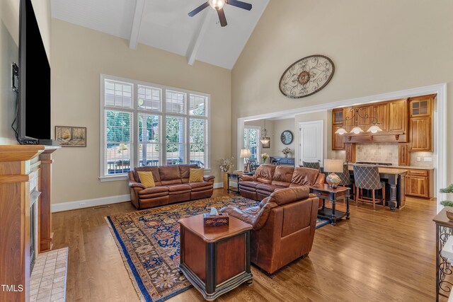 105 Somerley Dr, Garner, NC 27529 - living area featuring high vaulted ceiling, a ceiling fan, light wood-type flooring, beam ceiling, and a fireplace