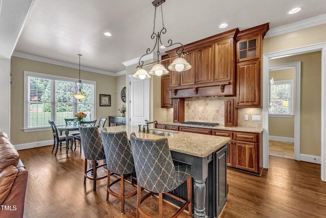 105 Somerley Dr, Garner, NC 27529 - kitchen featuring a sink, baseboards, stainless steel gas stovetop, a breakfast bar area, and dark wood-type flooring