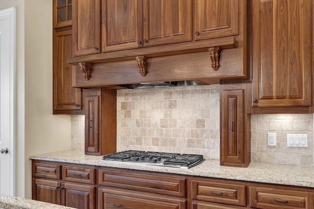 105 Somerley Dr, Garner, NC 27529 - kitchen with stainless steel gas stovetop, tasteful backsplash, and brown cabinetry