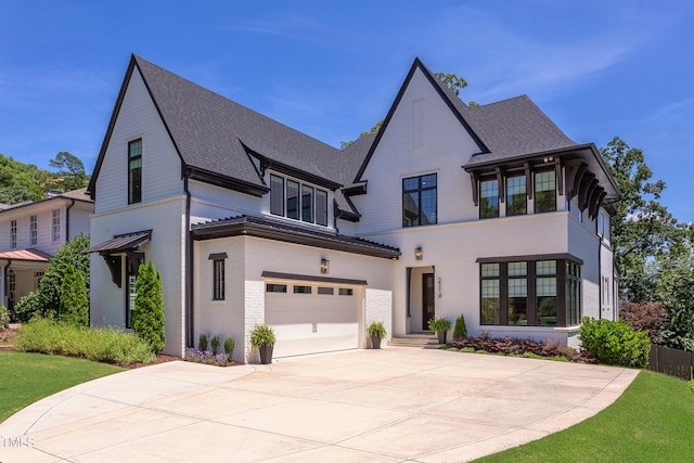 2114 Cowper Dr, Raleigh, NC 27608 - view of front of home featuring a garage, driveway, brick siding, and a shingled roof