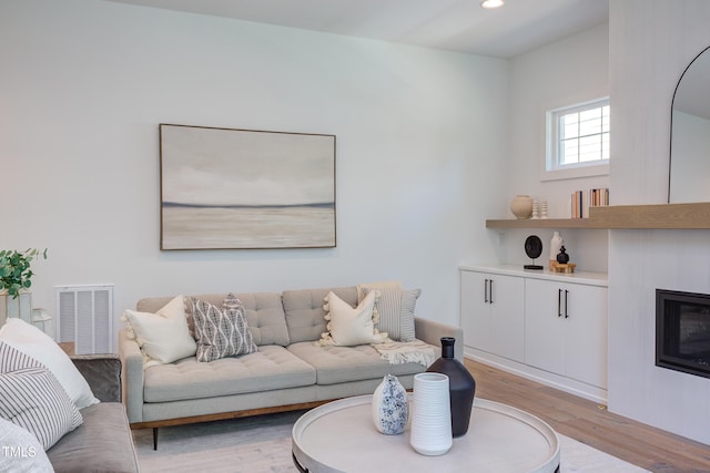 2114 Cowper Dr, Raleigh, NC 27608 - living area with a glass covered fireplace, light wood-style floors, and recessed lighting