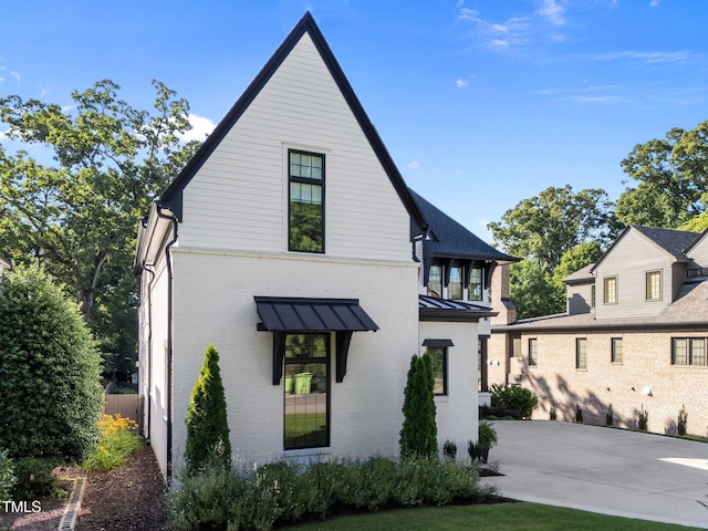2114 Cowper Dr, Raleigh, NC 27608 - view of front of house with brick siding, a standing seam roof, and a metal roof