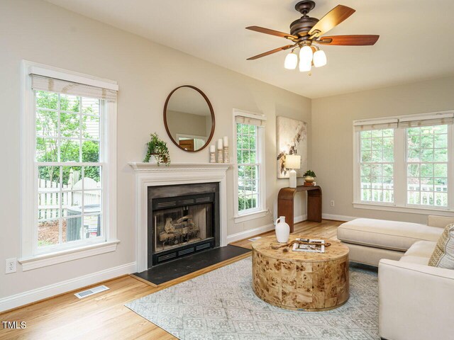 9020 Branch Creek Way, Apex, NC 27539 - living area with wood finished floors, healthy amount of natural light, a fireplace, and a ceiling fan