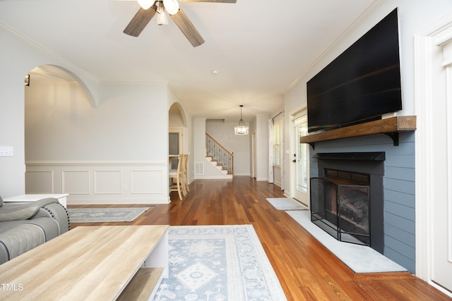 150 Churchill Rd, Louisburg, NC 27549 - living room featuring arched walkways, stairs, a fireplace, ceiling fan, and wood finished floors