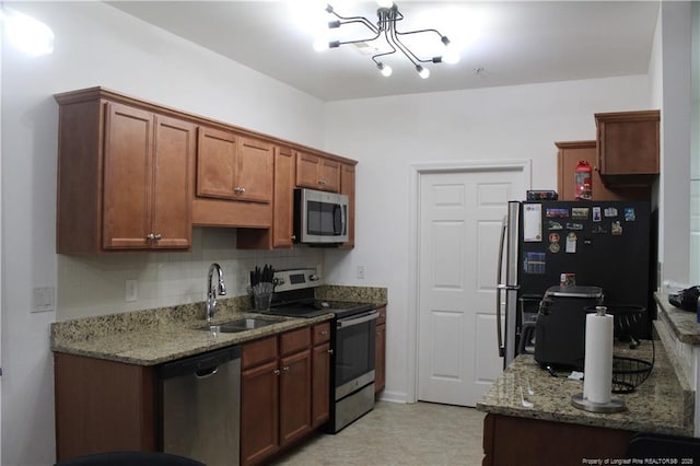 625 Marshtree Ln Unit 101, Fayetteville, NC 28314 - kitchen featuring stainless steel appliances, a sink, a chandelier, light stone countertops, and decorative backsplash