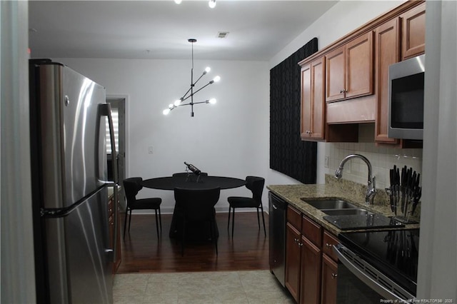 625 Marshtree Ln Unit 101, Fayetteville, NC 28314 - kitchen with appliances with stainless steel finishes, a sink, stone countertops, a chandelier, and tasteful backsplash