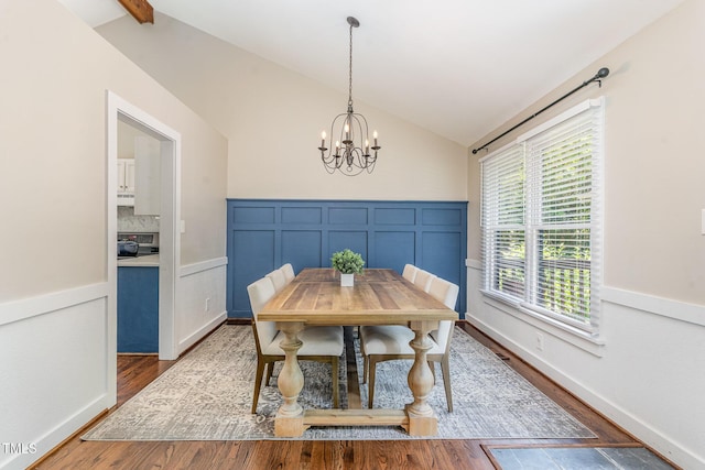 5617 Groomsbridge Ct, Raleigh, NC 27612 - dining space featuring vaulted ceiling, a chandelier, wood finished floors, plenty of natural light, and a decorative wall