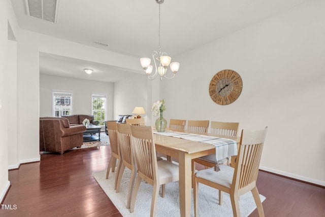106 Elmsford St, Durham, NC 27703 - dining area with dark wood-style floors, a chandelier, and baseboards